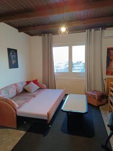 a bedroom with a bed and a couch and a window at Domi's Rooftop Apartment in Thessaloniki