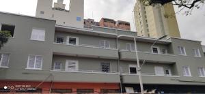 un bâtiment avec des fenêtres blanches et un grand bâtiment dans l'établissement Hotel MQ, à Belo Horizonte