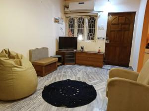 a living room with a couch and a television at Bungalow at Porvorim, Panaji in Panaji