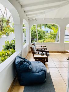 een patio met tafels, stoelen en ramen bij Hillcrest in Nassau