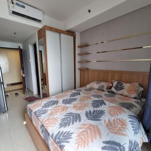 a bedroom with a large bed with a wooden headboard at Springwood Residence by Tentrem Room in Warungmangga