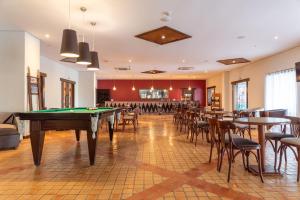 a pool table in a room with tables and chairs at Vila Galé Fortaleza in Fortaleza