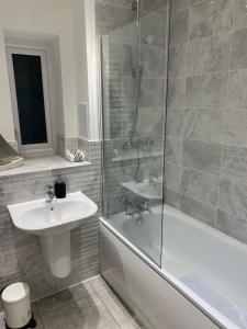y baño con ducha, lavabo y bañera. en BRAND NEW LUXURY 3 BED HOME with MULTIPLE FREE PARKING BAYS Early Check-in Late Check- Out Allowed, en West Thurrock