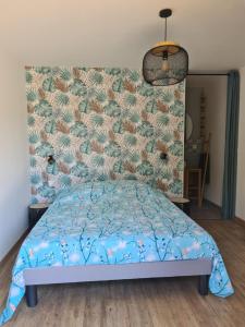 a bedroom with a bed with a blue comforter at Villas Floryanne in Parentis-en-Born +23 photos