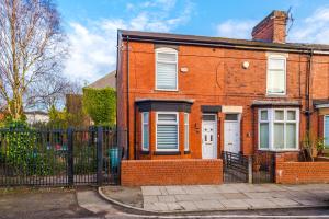 a red brick house with a black fence at 4 Bedroom Victorian House in Manchester