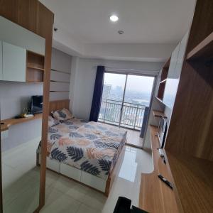 a bedroom with a bed and a large window at Springwood Residence by Tentrem Room in Warungmangga