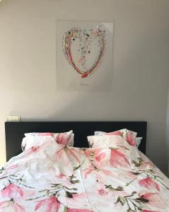 um quarto com uma cama com um coração na parede em Duplex avec superbe vue boisée em Esneux