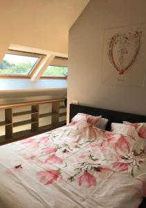 a bedroom with a bed with flowers on it at Duplex avec superbe vue boisée in Esneux