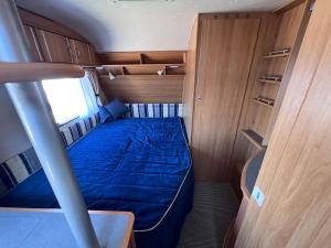 a small room with a bed in the back of a boat at Przyczepy kempingowe Chałupy 6 KitePL - KITE & WIND & WING in Chałupy