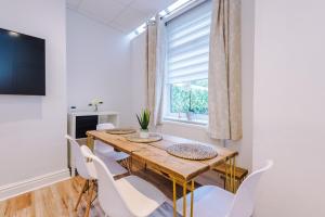a dining room with a wooden table and white chairs at 4 Bedroom Victorian House in Manchester