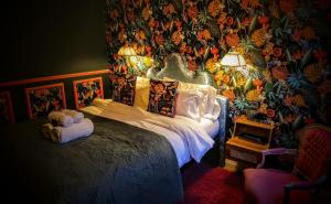 um quarto com uma cama com uma parede floral em The Mad Hatter em Oxford