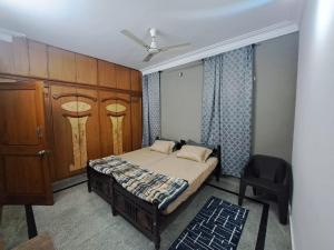 a bedroom with a bed and a cabinet and a chair at 3 Bedroom Duplex Villa With Private Pool Bangalore in Bangalore