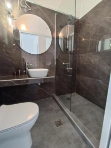 un bagno con un water, un lavandino e uno specchio di Alexander apartment 3 a Spartià Altre 17 foto