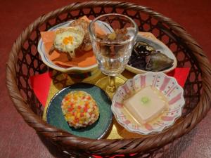 a table with plates of food and a glass at IZUNA INN & SPA - the veggie delights in Ito