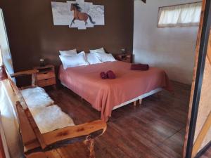 Un dormitorio con una cama y suelo de madera. en Cabaña sureña, en San Carlos de Bariloche