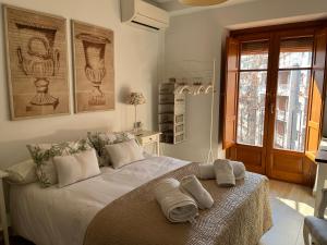 a bedroom with a bed with towels on it at Fantastico Apartamento Suite en centro de Granada in Granada