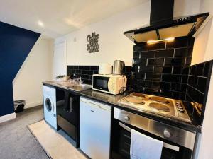 una cucina con piano cottura e forno a microonde di Stay in Style - Charming Central Studio a Liverpool