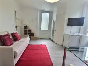sala de estar con sofá blanco y alfombra roja en Cosy des Rêves *Paris*Disney*, en Croissy-Beaubourg