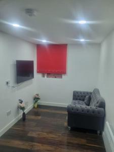 ein Wohnzimmer mit einem Sofa und einem Flachbild-TV in der Unterkunft 1 Bedroom Apartment in Daventry