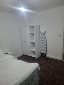 a bedroom with a bed and a white cabinet at 1 Bedroom Apartment in Daventry