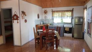 eine Küche mit einem Tisch und Stühlen im Zimmer in der Unterkunft Cabaña Martita in Pucón