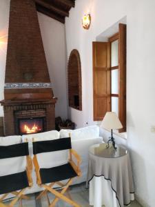 una sala de estar con chimenea y muebles blancos. en Casa Aracena "La Capilla de Aracenilla", en Aracena 26 fotos más