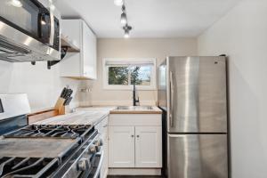 a kitchen with white cabinets and a stainless steel refrigerator at Kozy Cabin in Allenspark