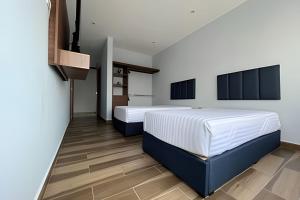 a bedroom with two beds and a tv on the wall at Departamento para grupos grandes in Mexico City