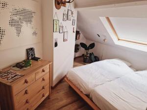 a bedroom with a bed and a dresser and a window at Lightful architectural house in Ghent