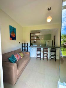 uma sala de estar com um sofá e uma cozinha em Apartamentos na Ponta dos Castelhanos - Anchieta em Anchieta