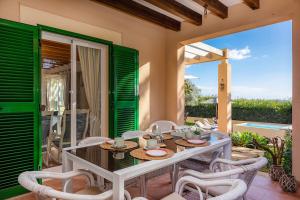 a dining room with a table and chairs on a patio at Finca Sa Copinya, frente a la costa de Cala Bona in Son Servera