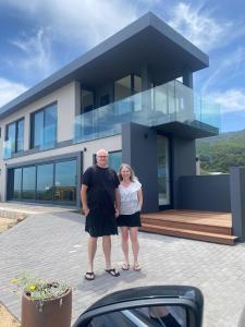 a man and woman standing in front of a house at Marien Beach House in Glentana