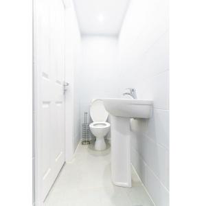 a white bathroom with a toilet and a sink at Stylish Studio in Moseley Village in Birmingham