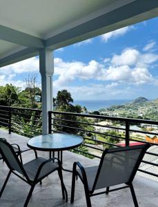a patio with two chairs and a table on a balcony at Ridge View in Kingstown