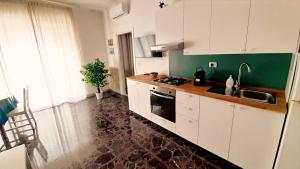 a kitchen with white cabinets and a counter top at Dimore Demetra in Canosa di Puglia