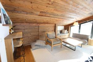 Habitación con pared de madera, escritorio y silla. en Heinrida en Saas-Fee