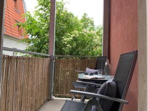 un tavolo e sedie su un balcone con recinzione di Appartement "Stadtnest" im Zentrum von Bautzen mit WLAN und gratis Kaffee a Bautzen