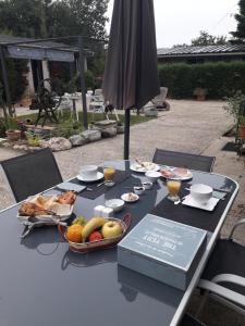 a table with a bowl of fruit and an umbrella at Chambres d'Hôtes de l'Ile du Saule in Saumur