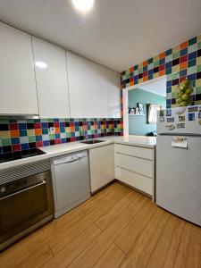 リスボンにあるLisbon design flat in Principe Realのキッチン(白いキャビネット、冷蔵庫付)