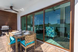 Acqua di Mare Resort في ويست باي: غرفة طعام بأبواب زجاجية وطاولة وكراسي