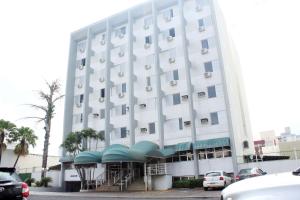 a large white building with cars parked in front of it at Days inn by Wyndham Uberlândia in Uberlândia