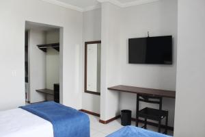 um quarto com uma cama, uma secretária e uma televisão em Days inn by Wyndham Uberlândia em Uberlândia