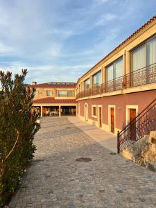 a building with a cobblestone street in front of it at Quinta de VillaSete in Alpendurada
