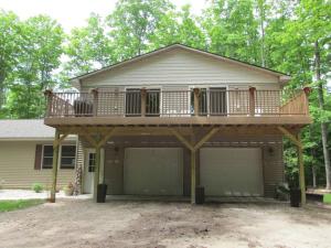 a house with a deck on top of it at Beulah Land Guest House w/King Bed & Jacuzzi Tub in Benzonia
