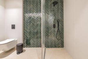 La salle de bains est pourvue d'une douche avec une porte en verre. dans l'établissement Porto Perla, à Kos