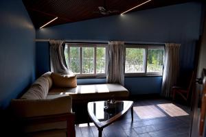 a living room with a couch and two windows at Olive in Tāla