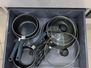 a drawer filled with pots and pans and other kitchen utensils at Charmante petite maison de ville avec balcon in Fréjus