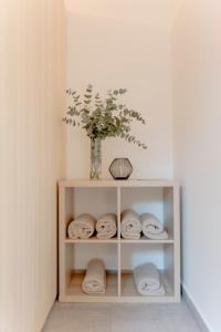 ein Regal mit Handtüchern und eine Vase mit Pflanze in der Unterkunft Villa Bardo in Opatija