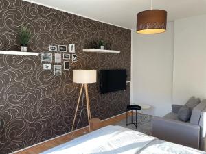 una camera da letto con divano e parete con carta da parati di Appartement "Stadtnest" im Zentrum von Bautzen mit WLAN und gratis Kaffee a Bautzen