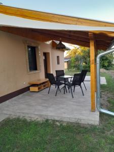 un patio con sedie, tavolo e una casa di Apartman Pored Jezera a Palić Altre 2 foto